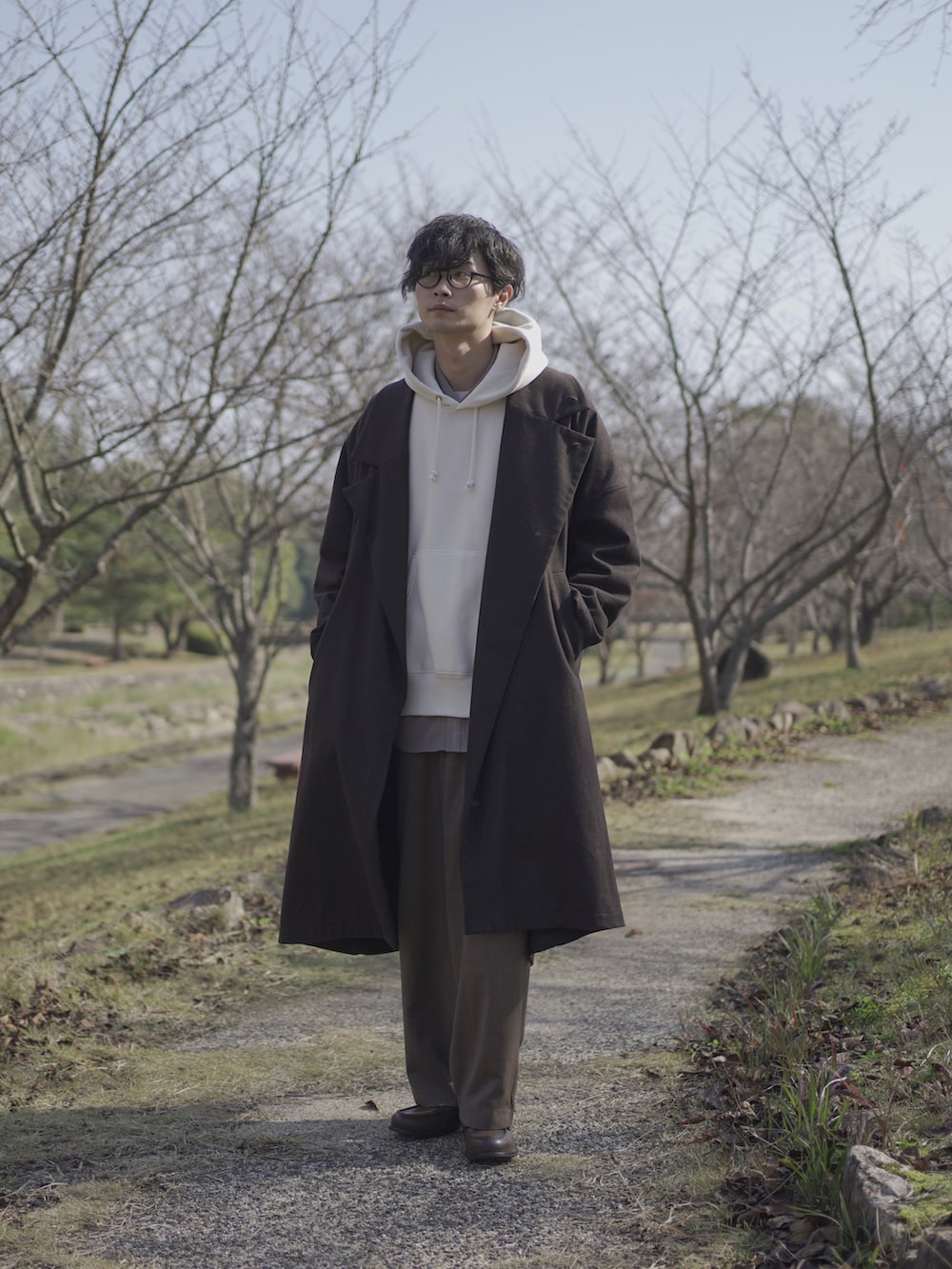 ホワイト系のパーカー、グレー系のトレンチコート、グレー系のシャツ/ブラウスを着用したメンズの秋コーディネートの3枚目の写真