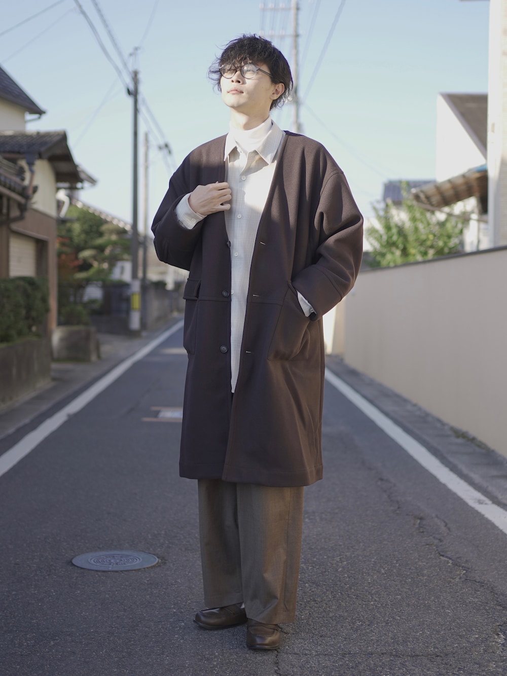 ブラウン系のノーカラーコート、ベージュ系のシャツ/ブラウス、ホワイト系のTシャツ/カットソーを着用したメンズの秋コーディネートの2枚目の写真