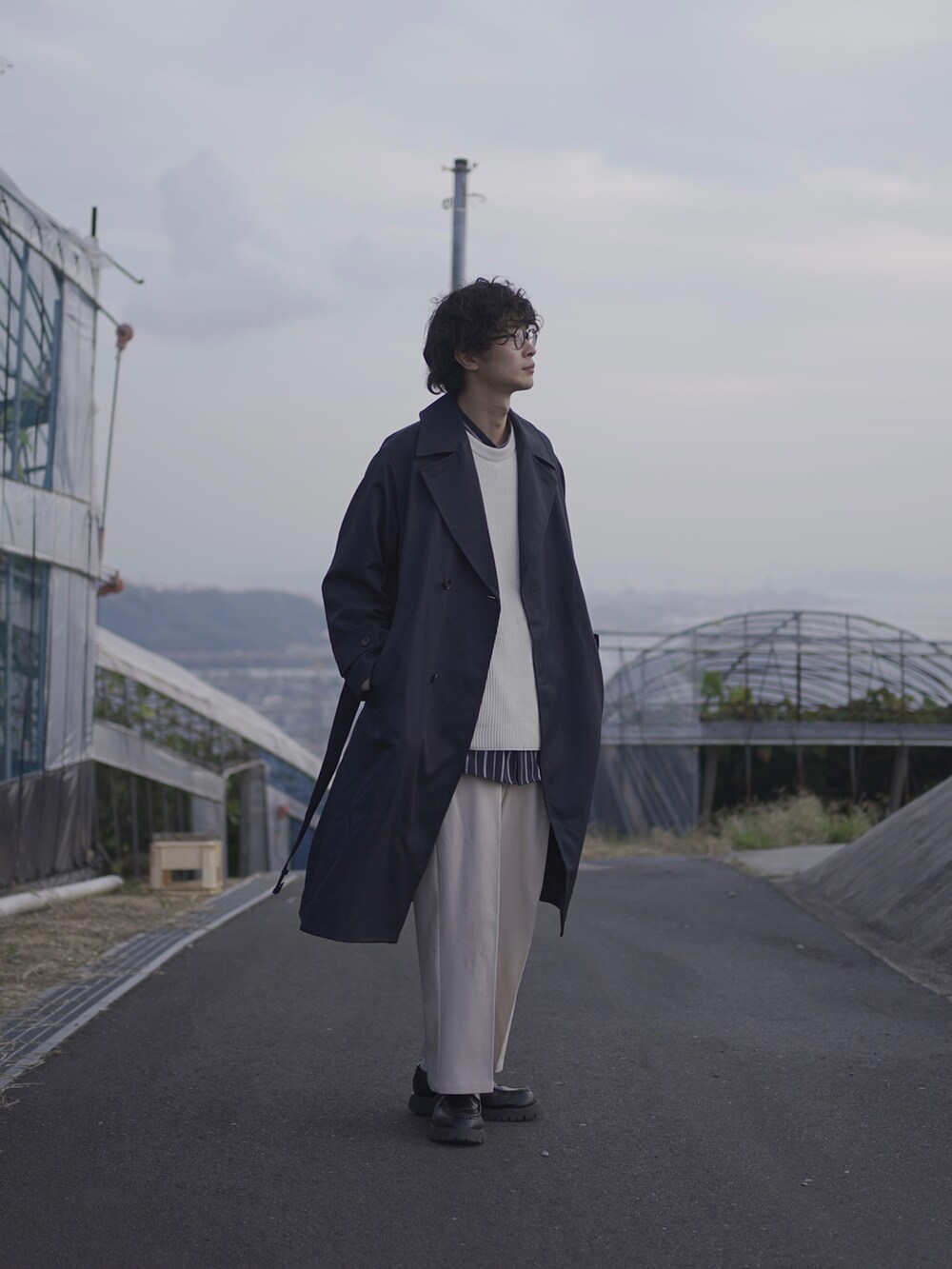 ブルー系のトレンチコート、ホワイト系のニット/セーター、ブルー系のシャツ/ブラウスを着用したメンズの秋コーディネートの2枚目の写真