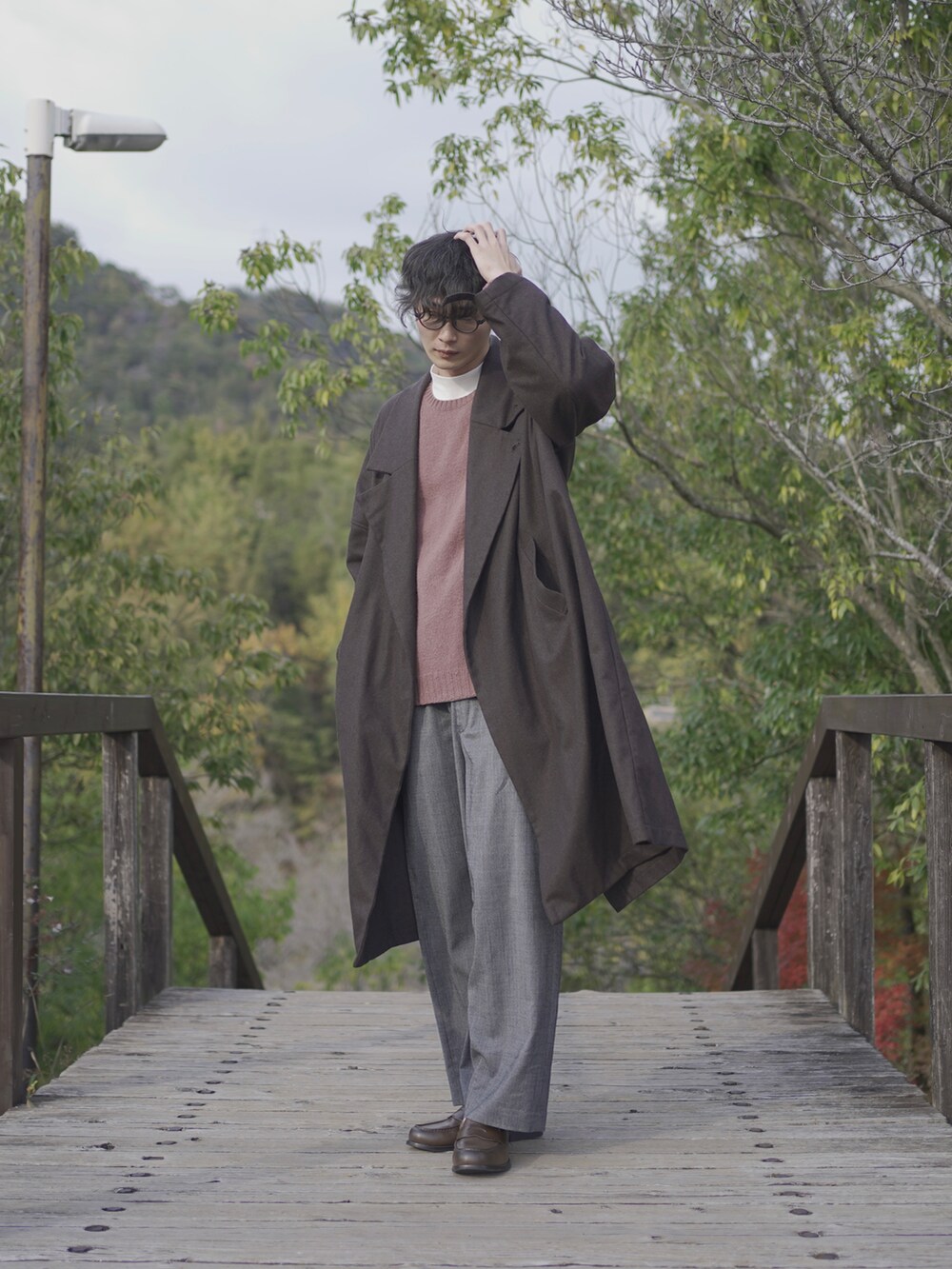 ブラウン系のトレンチコートを着用したメンズの秋コーディネートの2枚目の写真