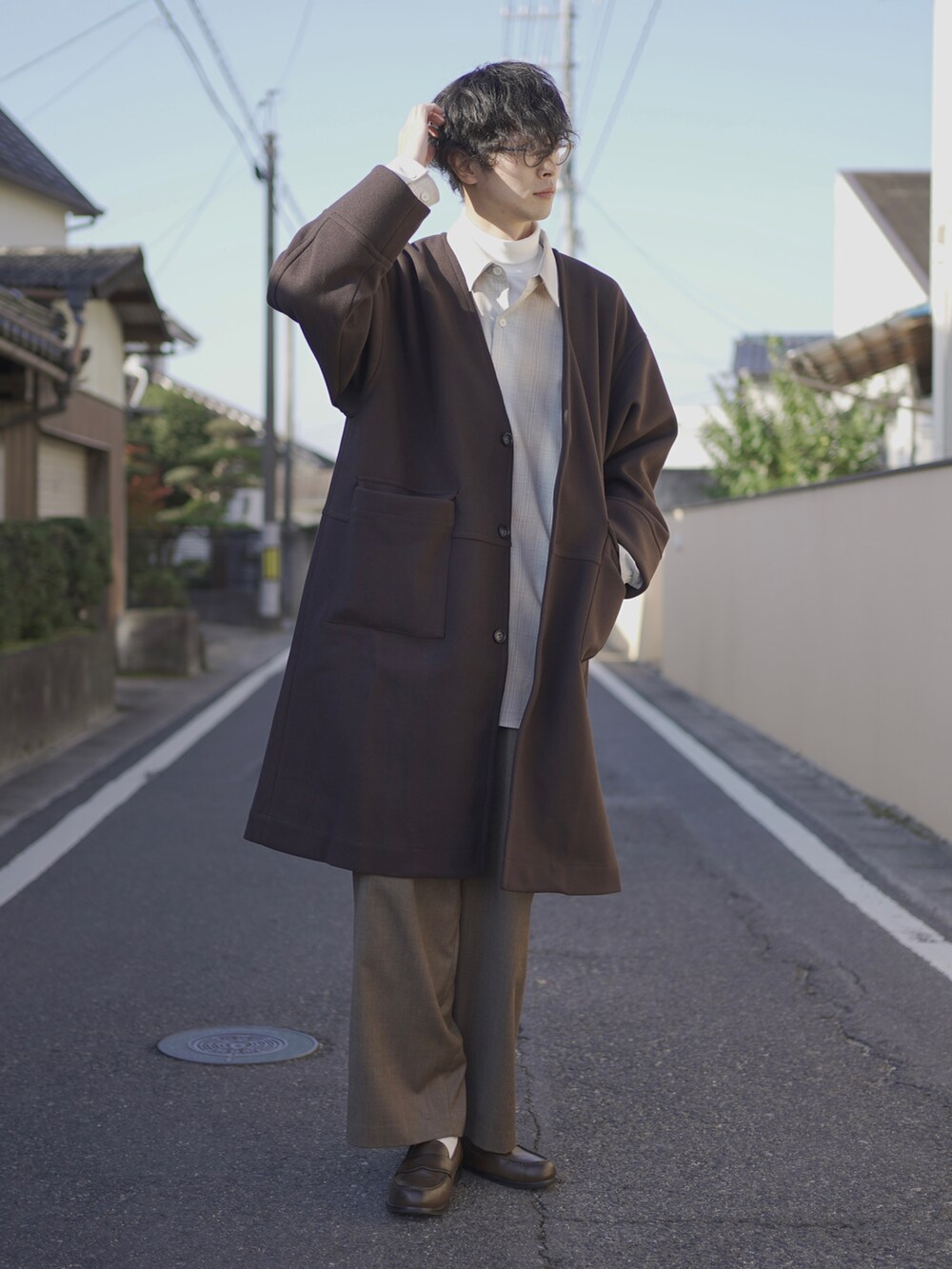 ブラウン系のノーカラーコート、ベージュ系のシャツ/ブラウス、ホワイト系のTシャツ/カットソーを着用したメンズの秋コーディネートの5枚目の写真