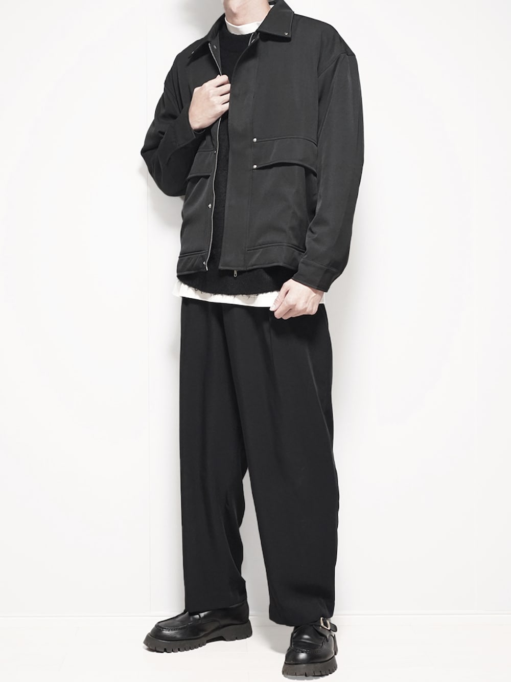 ブラック系のブルゾン、ブラック系のカーディガン/ボレロ、ホワイト系のTシャツ/カットソーを着用したメンズの秋コーディネートの2枚目の写真