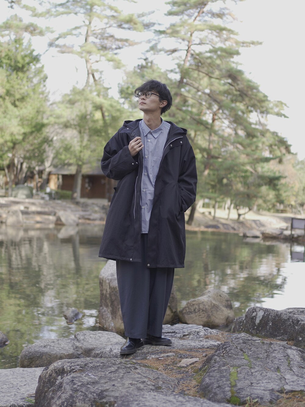 ブラック系のモッズコート、ブルー系のシャツ/ブラウス、ブルー系のスラックスを着用したメンズの冬コーディネートの2枚目の写真