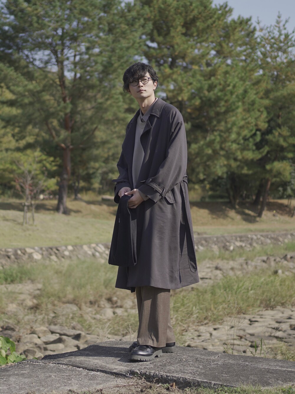 グレー系のトレンチコート、ベージュ系のベスト、グレー系のシャツ/ブラウスを着用したメンズの冬コーディネートの4枚目の写真