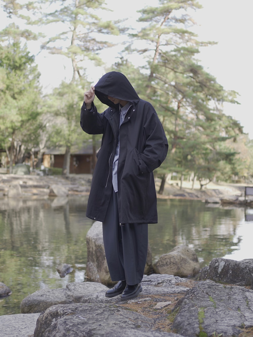 ブラック系のモッズコート、ブルー系のシャツ/ブラウス、ブルー系のスラックスを着用したメンズの冬コーディネートの4枚目の写真