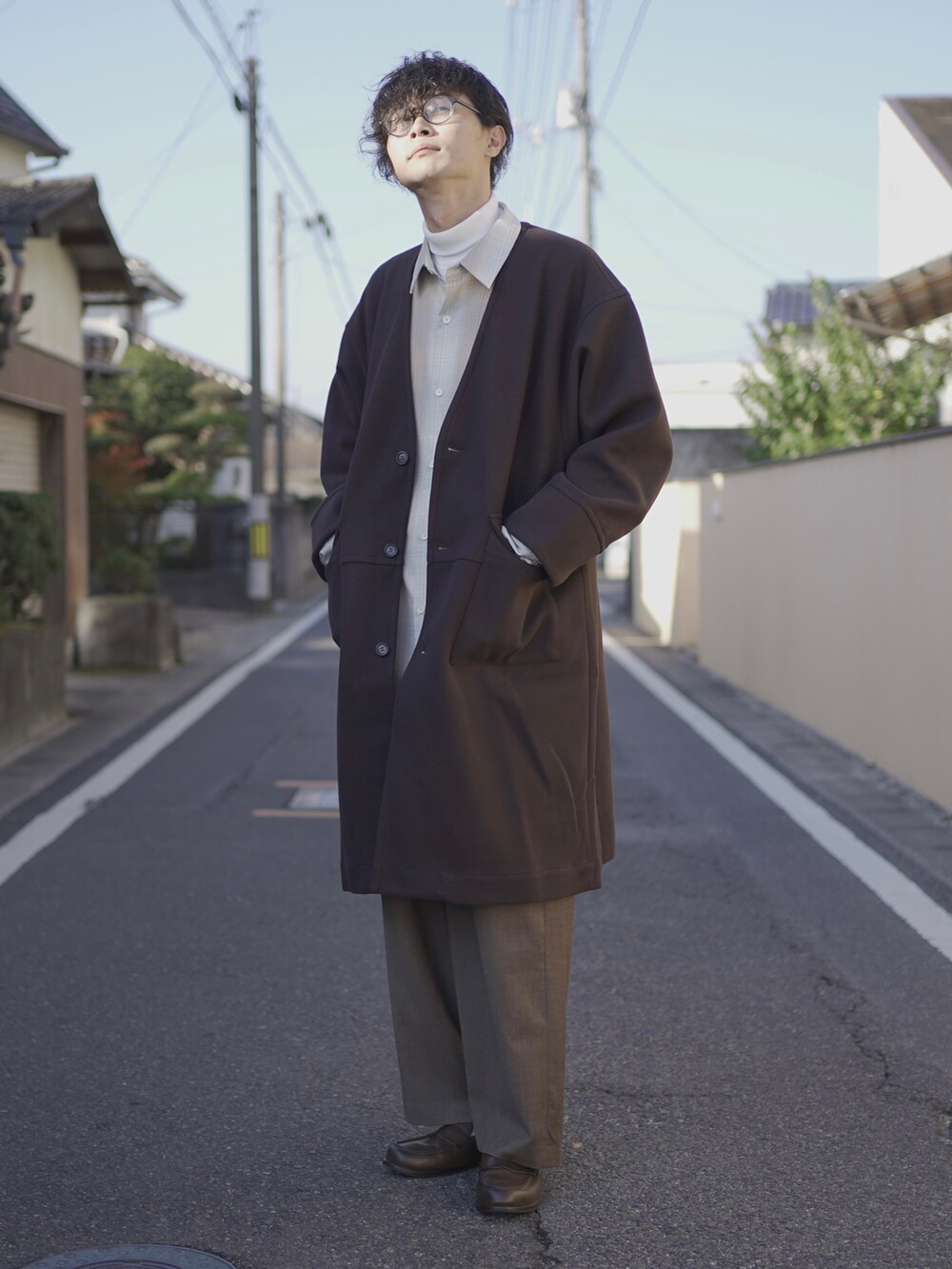 ブラウン系のノーカラーコート、ベージュ系のシャツ/ブラウス、ホワイト系のTシャツ/カットソーを着用したメンズの秋コーディネートの4枚目の写真