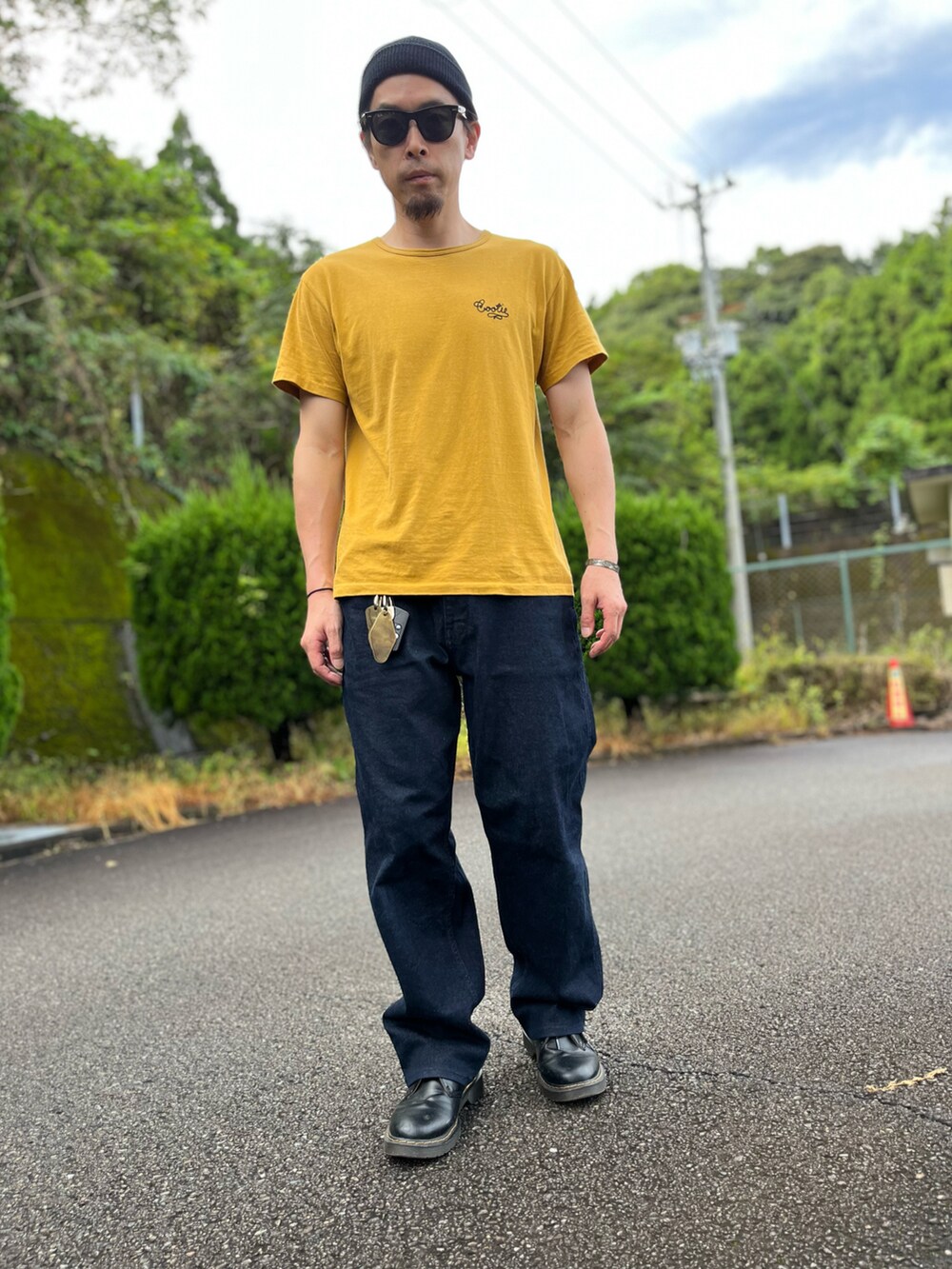 イエロー系のTシャツ/カットソー、ブルー系のパンツ、ブラック系のブーツを着用したメンズの秋コーディネートの5枚目の写真