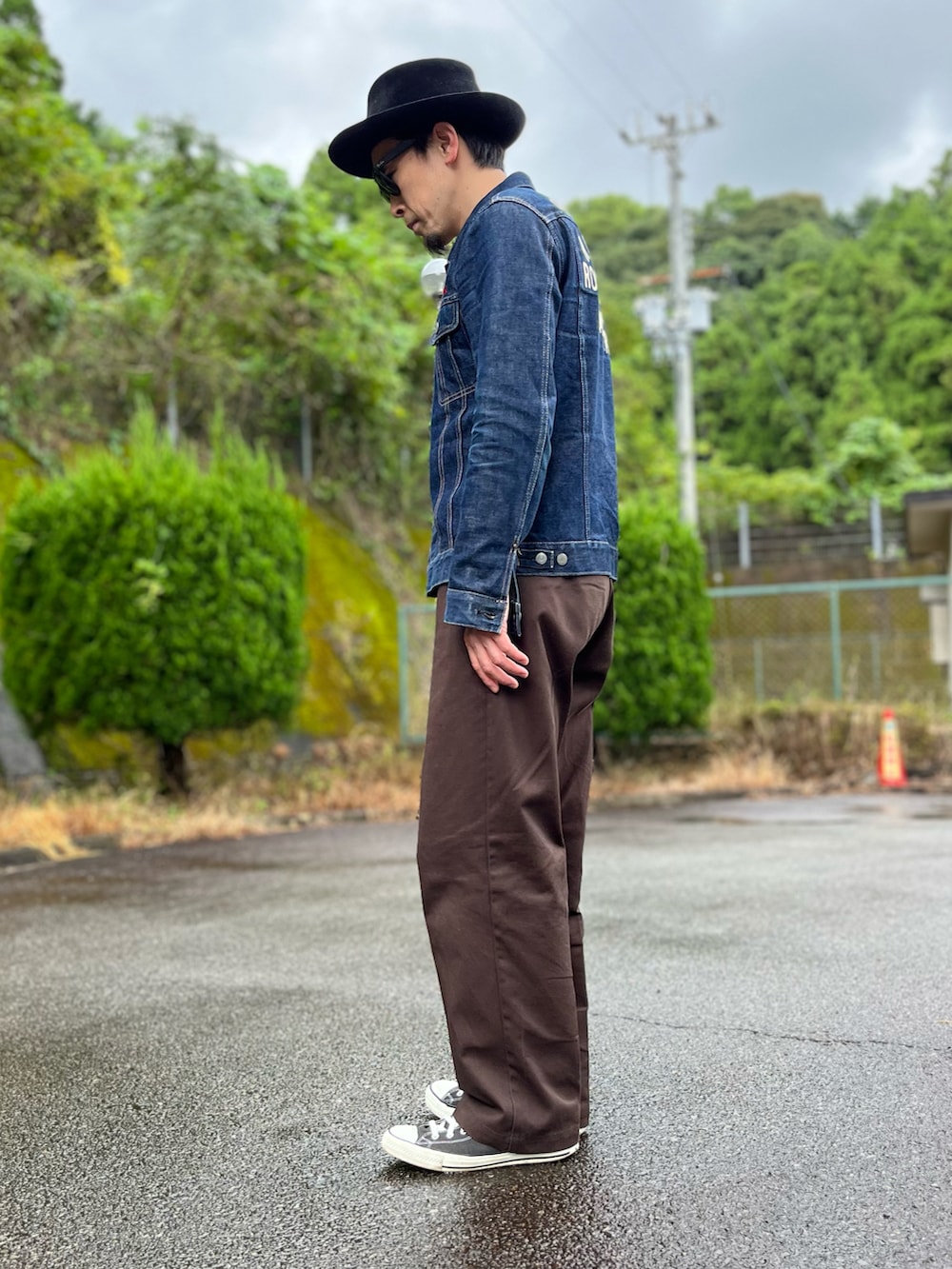 ブルー系のデニムジャケット、ブラウン系のチノパンツ、ブラック系のスニーカーを着用したメンズの秋コーディネートの4枚目の写真