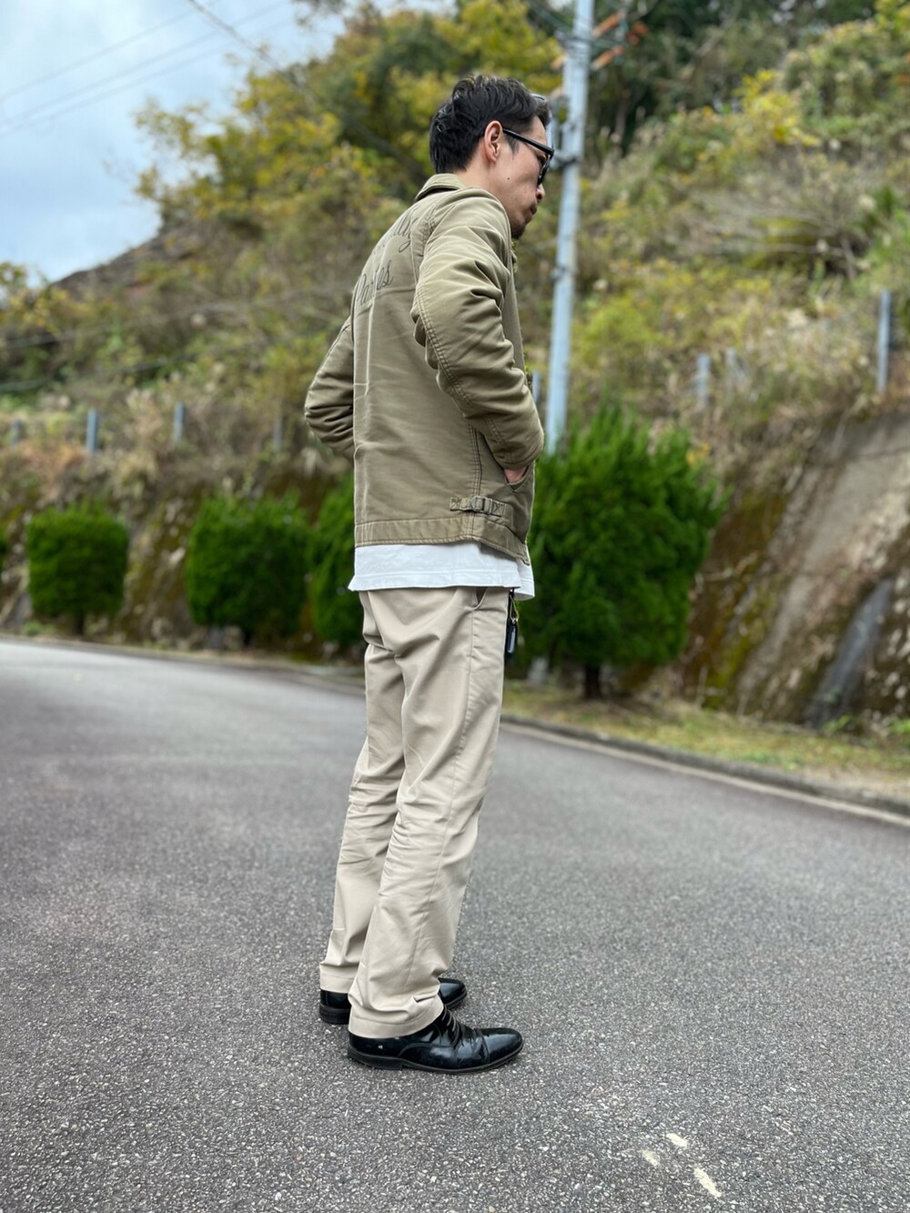 ホワイト系のTシャツ/カットソー、グリーン系のミリタリージャケット、ベージュ系のその他パンツを着用したメンズの冬コーディネートの2枚目の写真
