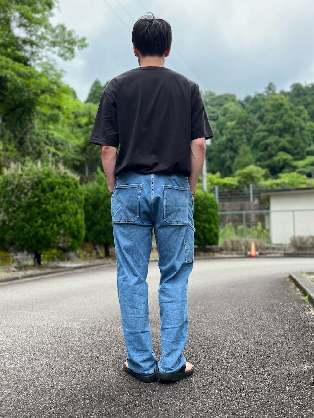 ブラック系のTシャツ/カットソー、ブルー系のパンツ、ブラック系のサンダルを着用したメンズの夏コーディネートの3枚目の写真