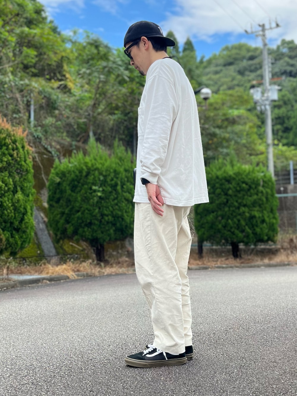 ホワイト系のTシャツ/カットソー、ホワイト系のパンツ、ブラック系のスニーカーを着用したメンズの秋コーディネートの2枚目の写真