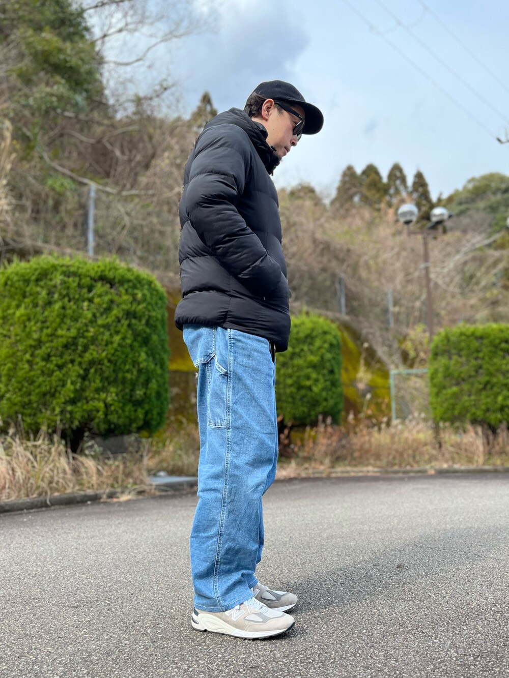 ブラック系のダウンジャケット/コート、ブルー系のパンツ、グレー系のスニーカーを着用したメンズの冬コーディネートの4枚目の写真