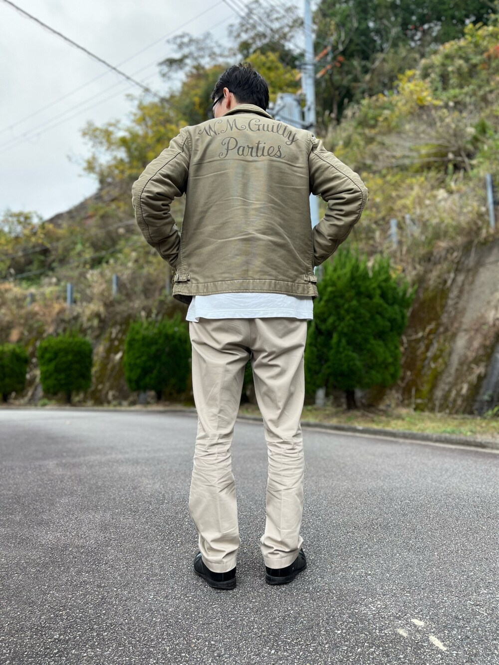 ホワイト系のTシャツ/カットソー、グリーン系のミリタリージャケット、ベージュ系のその他パンツを着用したメンズの冬コーディネートの3枚目の写真