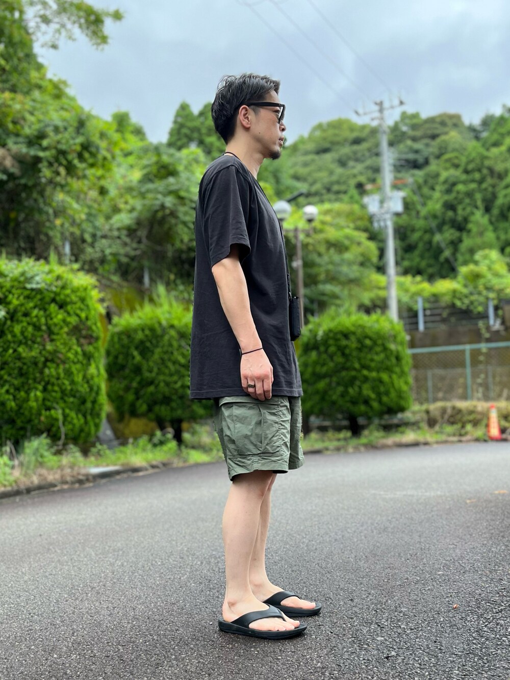 ブラック系のTシャツ/カットソー、グリーン系のその他パンツ、ブラック系のサンダルを着用したメンズの夏コーディネートの4枚目の写真