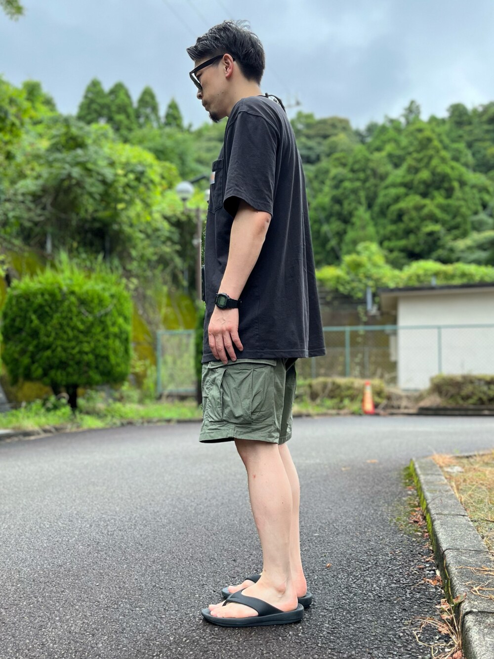 ブラック系のTシャツ/カットソー、グリーン系のその他パンツ、ブラック系のサンダルを着用したメンズの夏コーディネートの2枚目の写真
