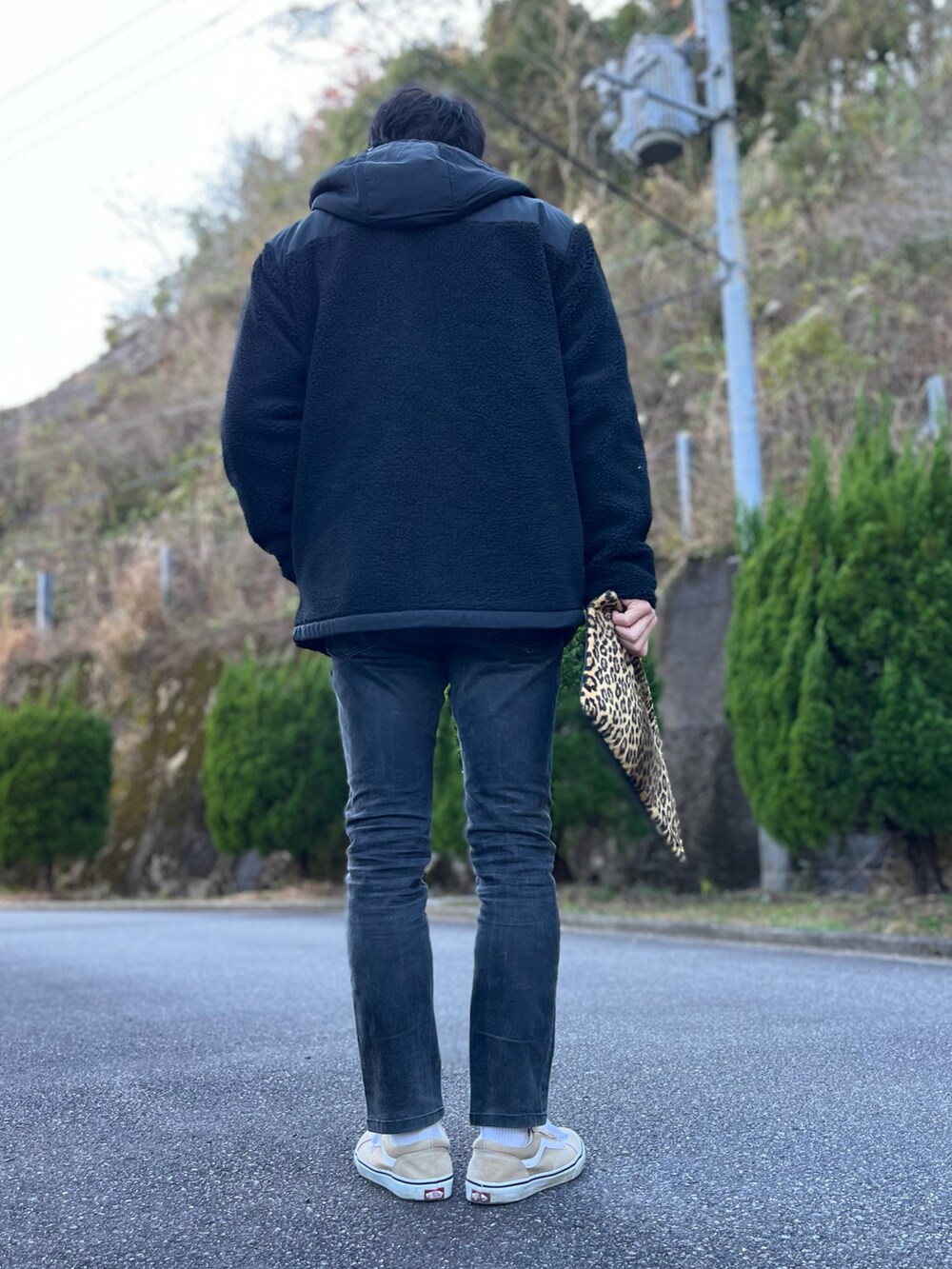 グレー系のスウェット、ブラック系のブルゾン、その他のクラッチバッグを着用したメンズの冬コーディネートの4枚目の写真