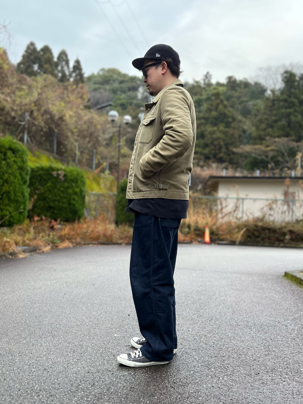 グリーン系のミリタリージャケット、ホワイト系のTシャツ/カットソー、ブルー系のパンツを着用したメンズの冬コーディネートの4枚目の写真
