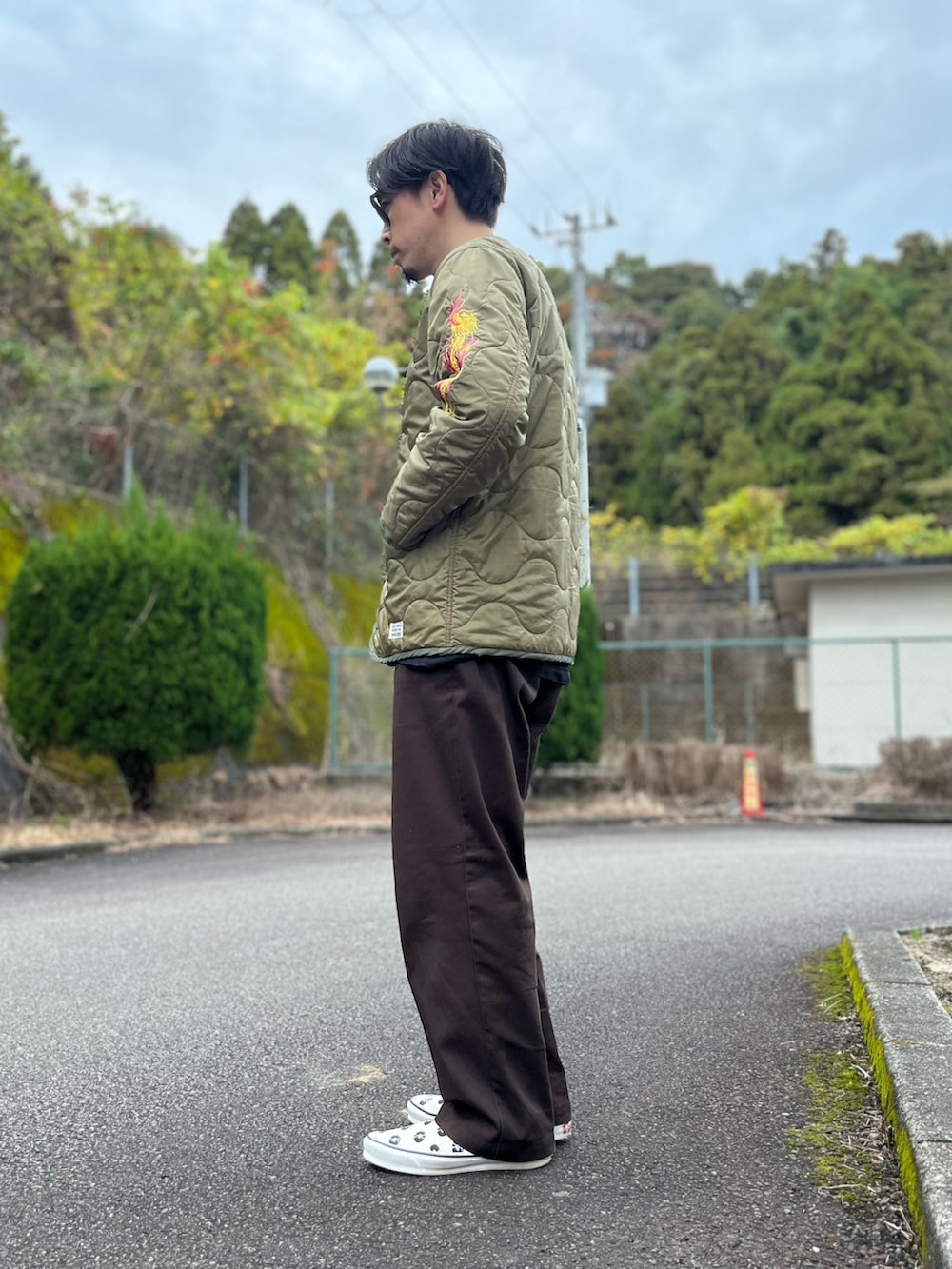 ホワイト系のTシャツ/カットソー、グリーン系のノーカラージャケット、ブラウン系のチノパンツを着用したメンズの冬コーディネートの2枚目の写真