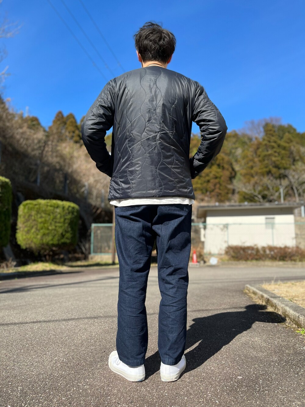 ホワイト系のTシャツ/カットソー、ブラック系のバッグ、ブルー系のパンツを着用したメンズの冬コーディネートの2枚目の写真