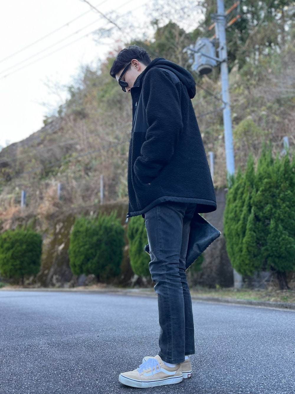 グレー系のスウェット、ブラック系のブルゾン、その他のクラッチバッグを着用したメンズの冬コーディネートの3枚目の写真