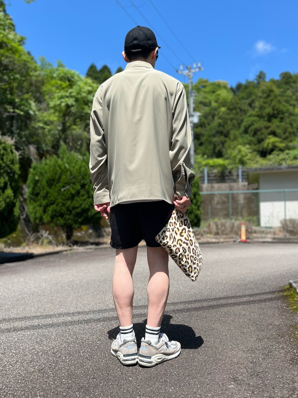 ブラック系のその他パンツ、その他のクラッチバッグ、グレー系のスニーカーを着用したメンズの春コーディネートの3枚目の写真