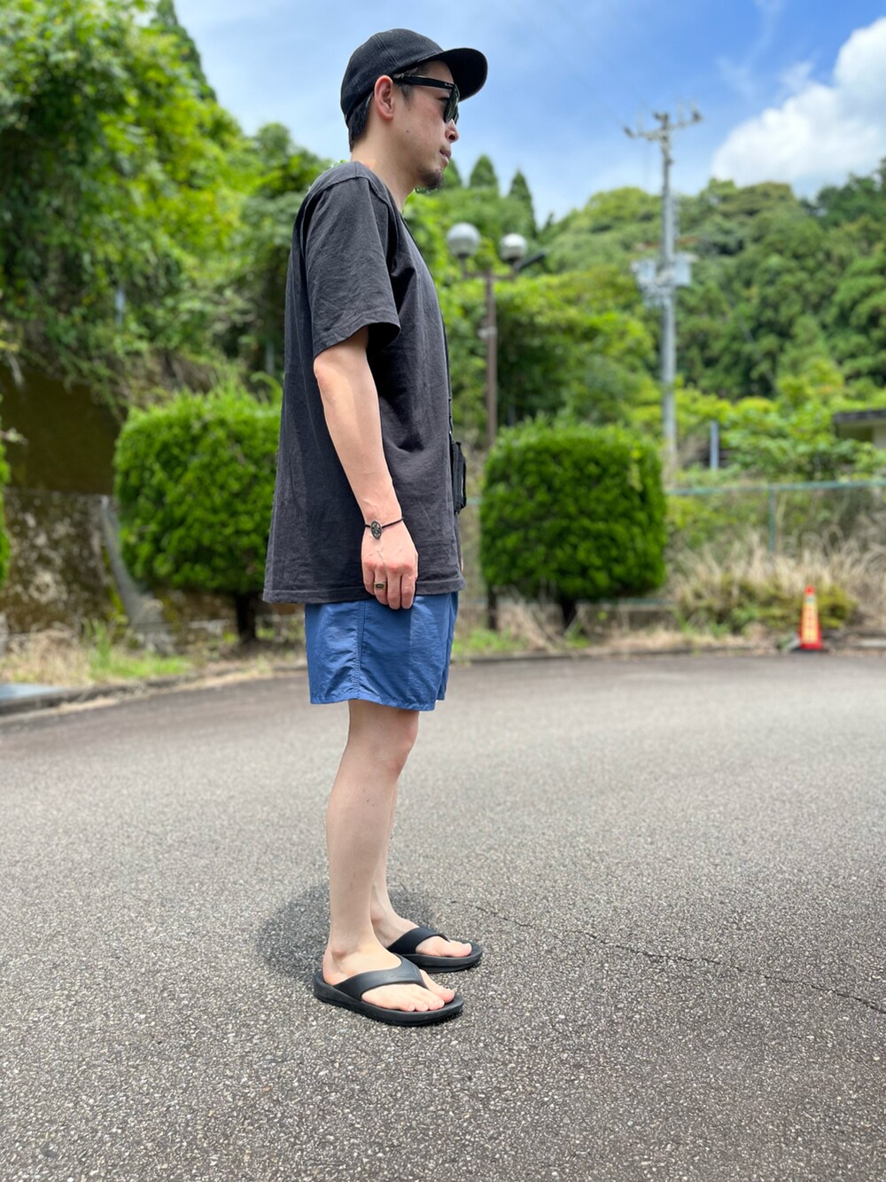ブラック系のTシャツ/カットソー、ブルー系のパンツ、ブラック系のサンダルを着用したメンズの夏コーディネートの3枚目の写真
