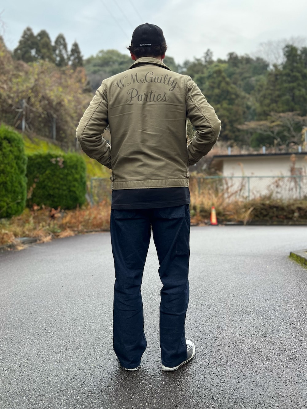 グリーン系のミリタリージャケット、ホワイト系のTシャツ/カットソー、ブルー系のパンツを着用したメンズの冬コーディネートの2枚目の写真