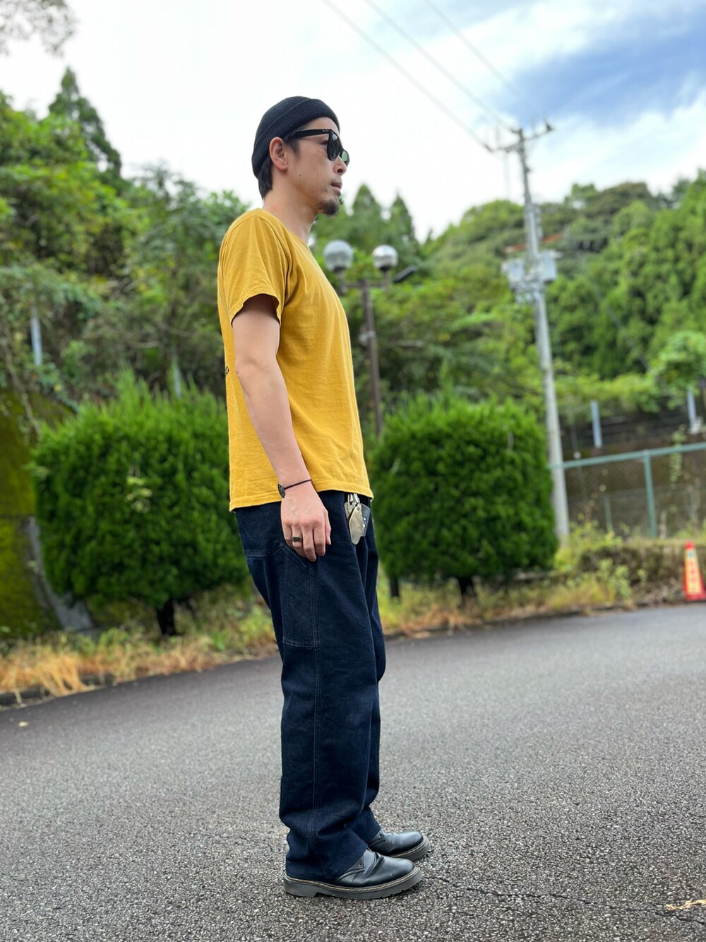 イエロー系のTシャツ/カットソー、ブルー系のパンツ、ブラック系のブーツを着用したメンズの秋コーディネートの4枚目の写真