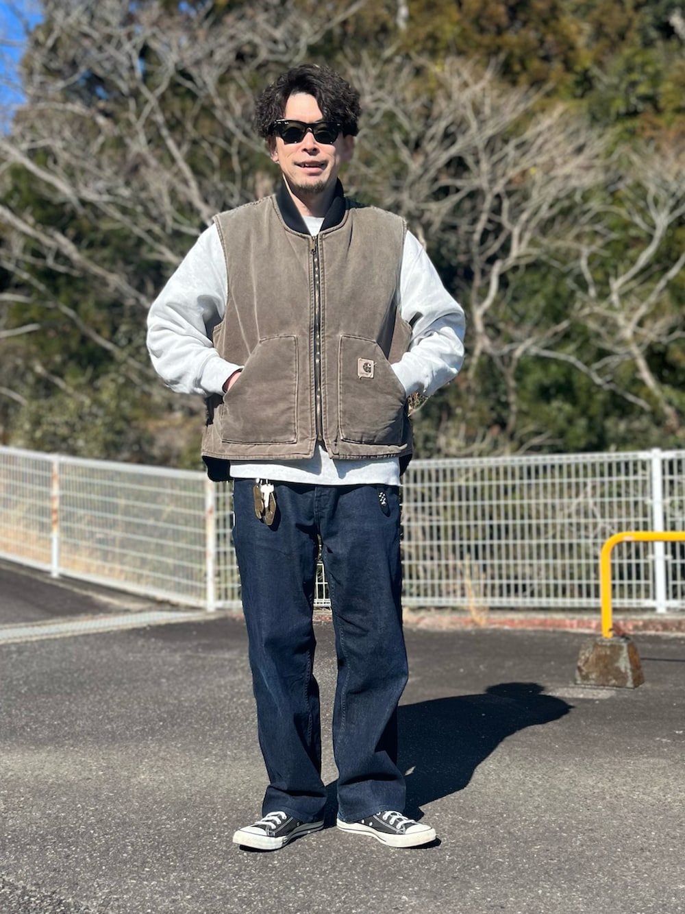 ブラウン系のダウンベスト、ブルー系のパンツ、ブラック系のスニーカーを着用したメンズの冬コーディネートの5枚目の写真