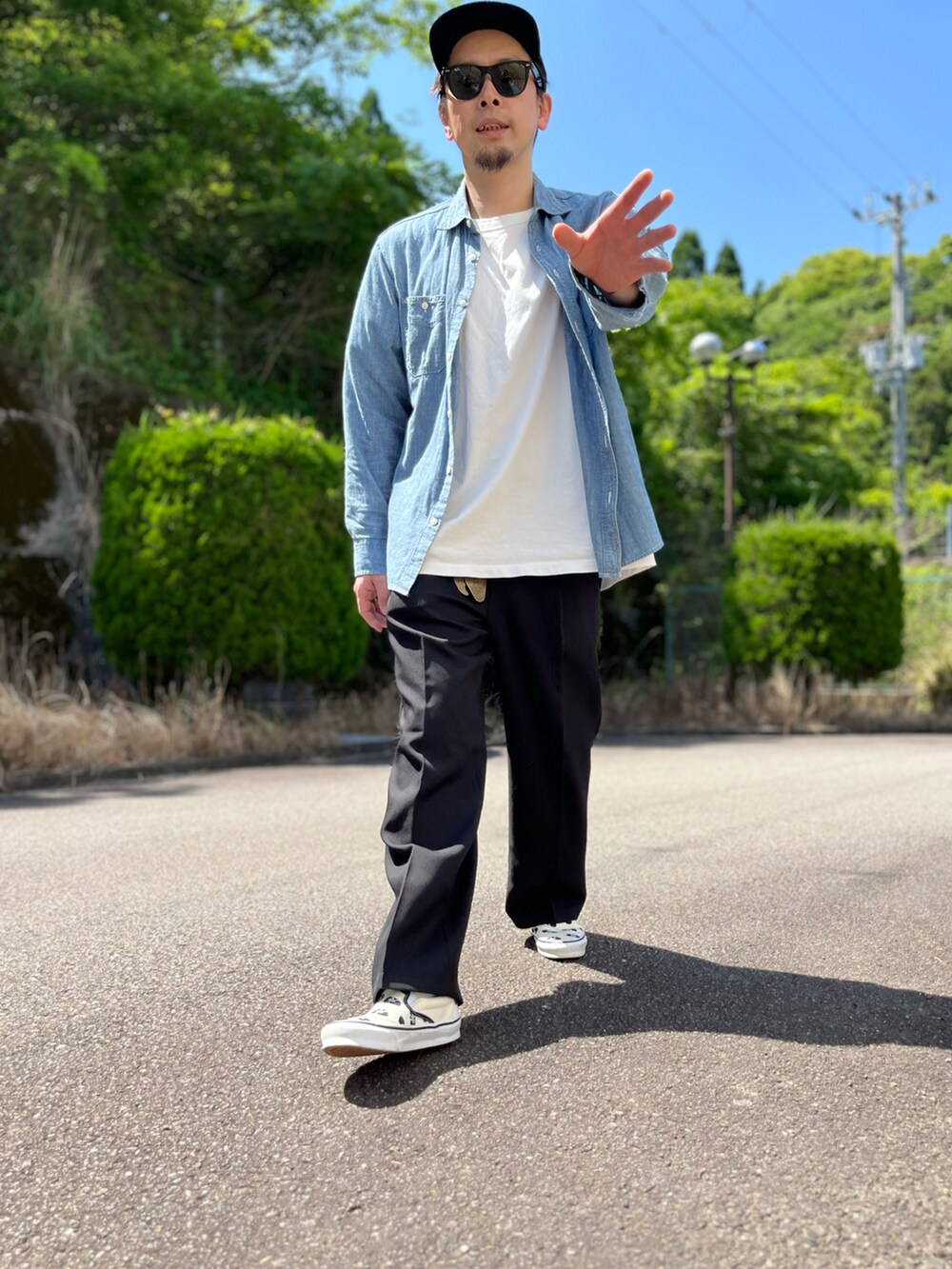 ホワイト系のTシャツ/カットソー、ブラック系のスラックス、ホワイト系のスリッポンを着用したメンズの春コーディネートの2枚目の写真
