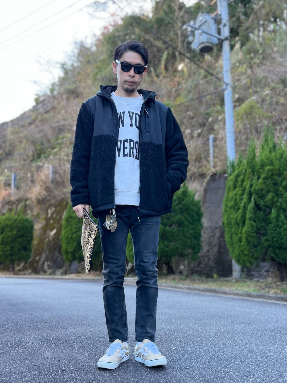 グレー系のスウェット、ブラック系のブルゾン、その他のクラッチバッグを着用したメンズの冬コーディネートの2枚目の写真