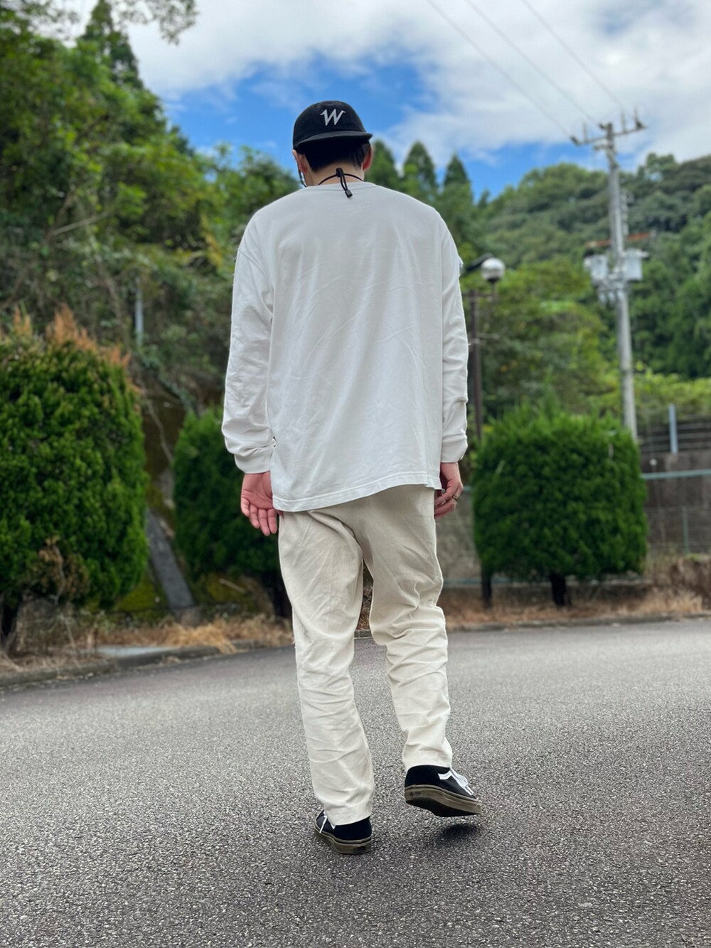 ホワイト系のTシャツ/カットソー、ホワイト系のパンツ、ブラック系のスニーカーを着用したメンズの秋コーディネートの3枚目の写真