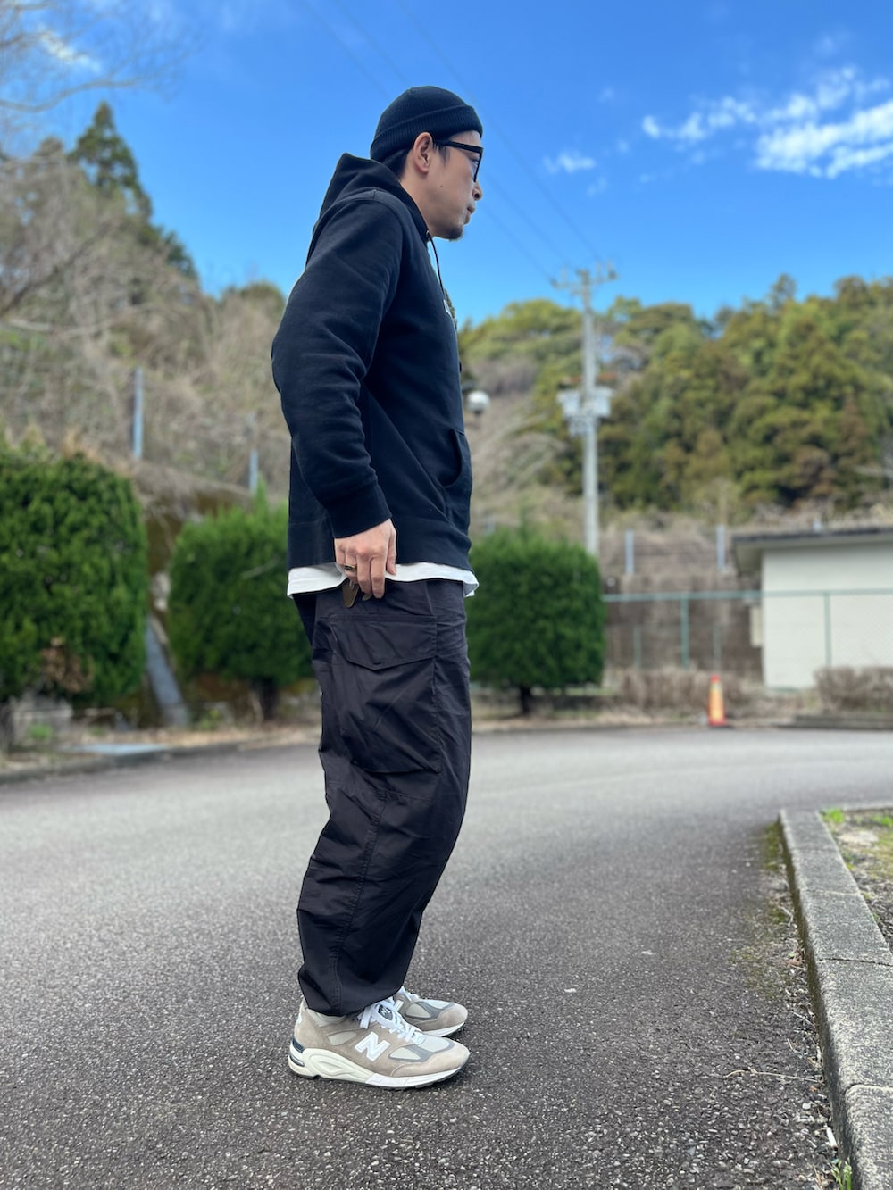 ブラック系のパーカー、ホワイト系のTシャツ/カットソー、グレー系のスニーカーを着用したメンズの冬コーディネートの2枚目の写真