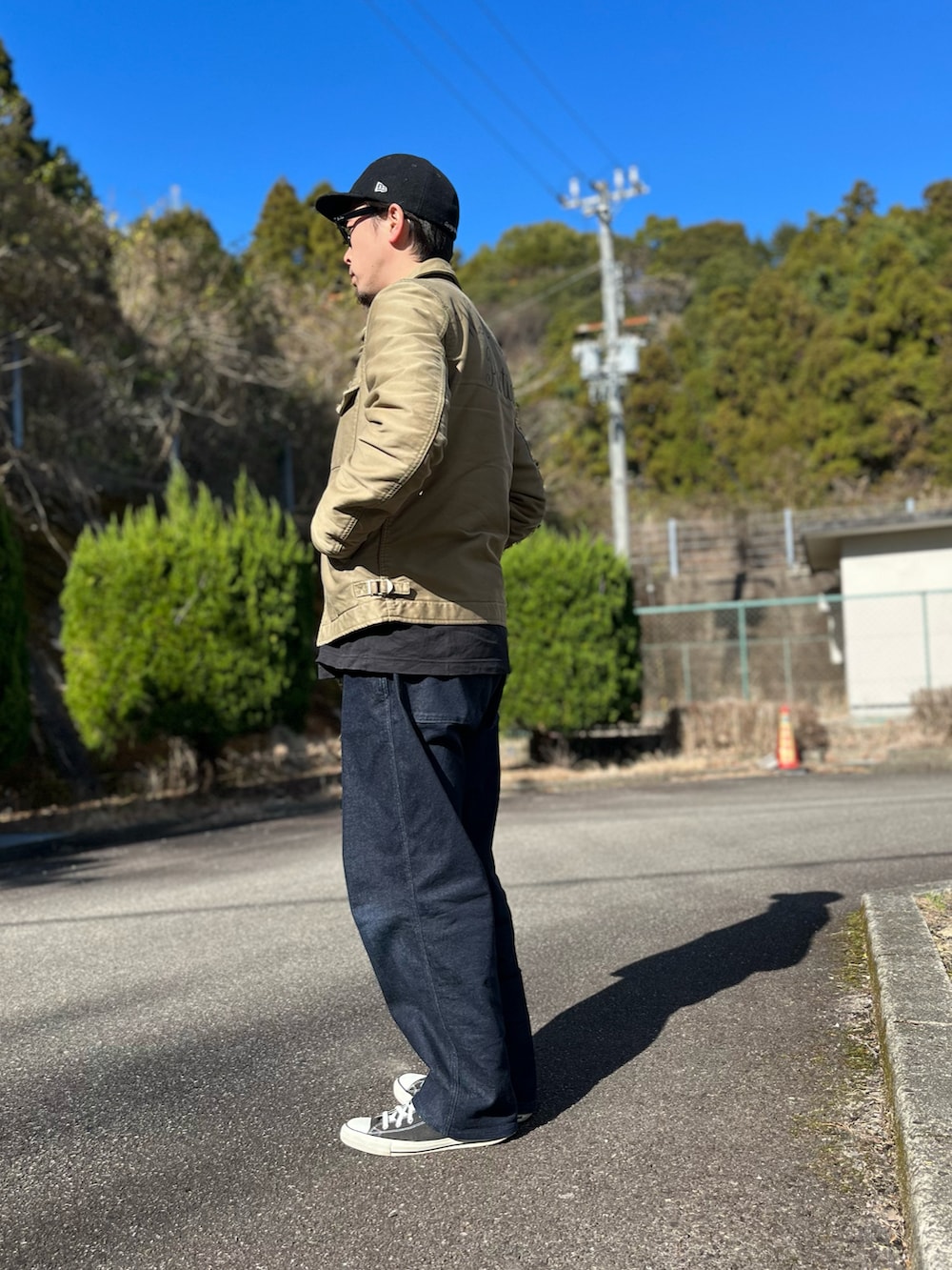 ホワイト系のTシャツ/カットソー、グリーン系のミリタリージャケット、ブルー系のパンツを着用したメンズの冬コーディネートの4枚目の写真