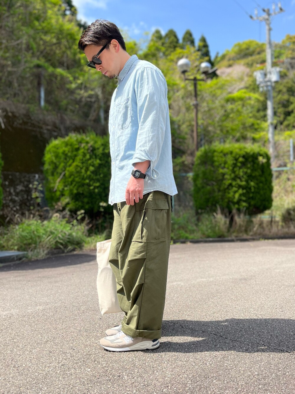 ブルー系のシャツ/ブラウス、ホワイト系のトートバッグ、グリーン系のカーゴパンツを着用したメンズの春コーディネートの4枚目の写真