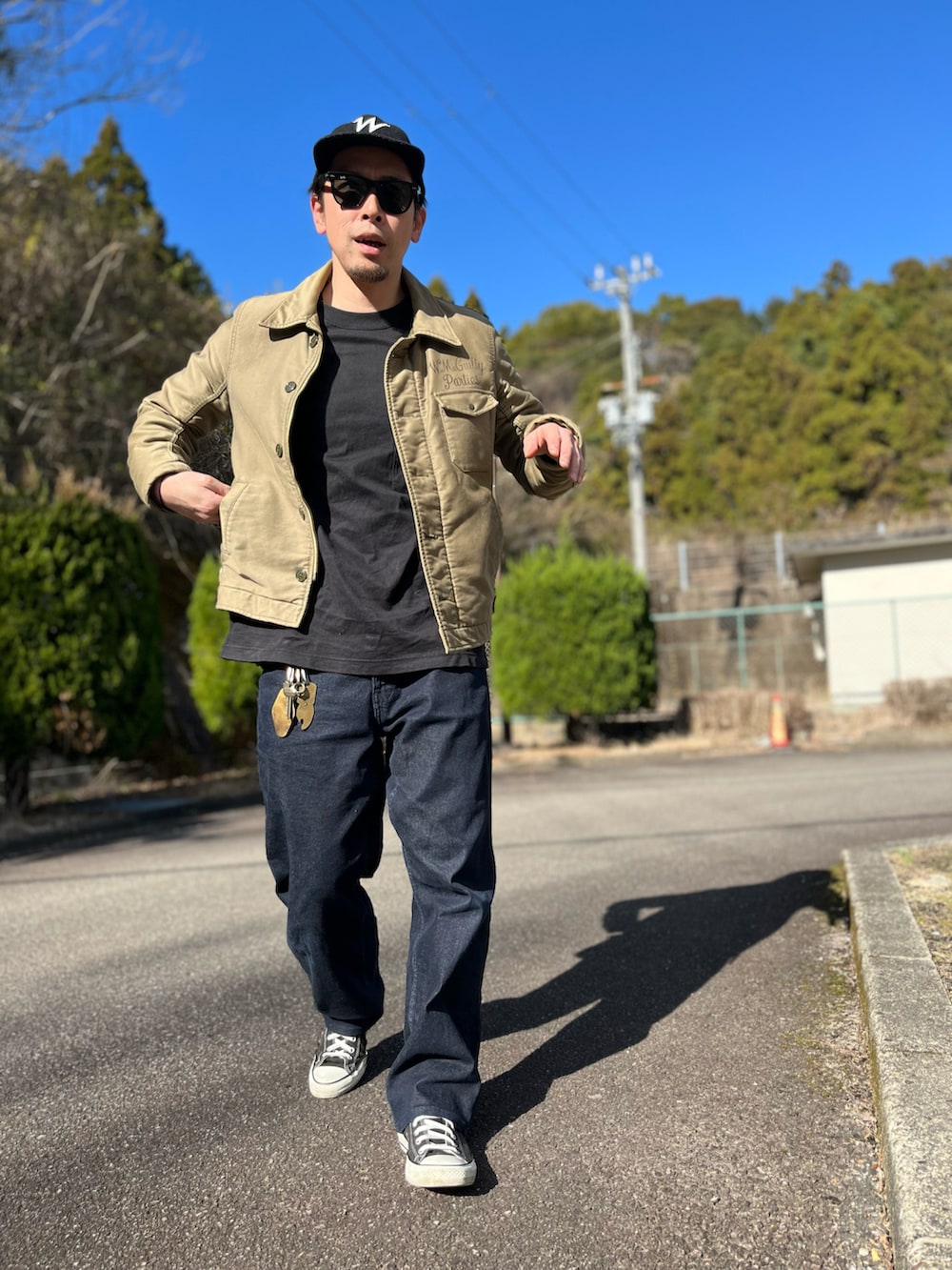 ホワイト系のTシャツ/カットソー、グリーン系のミリタリージャケット、ブルー系のパンツを着用したメンズの冬コーディネートの5枚目の写真