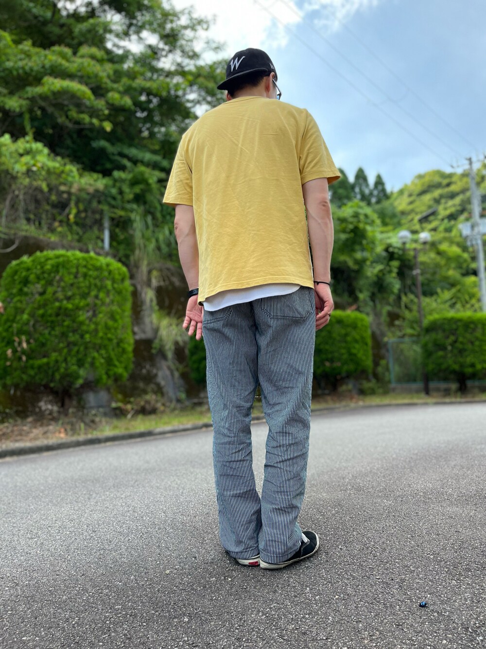 イエロー系のTシャツ/カットソー、ホワイト系のタンクトップ、グレー系のパンツを着用したメンズの夏コーディネートの3枚目の写真