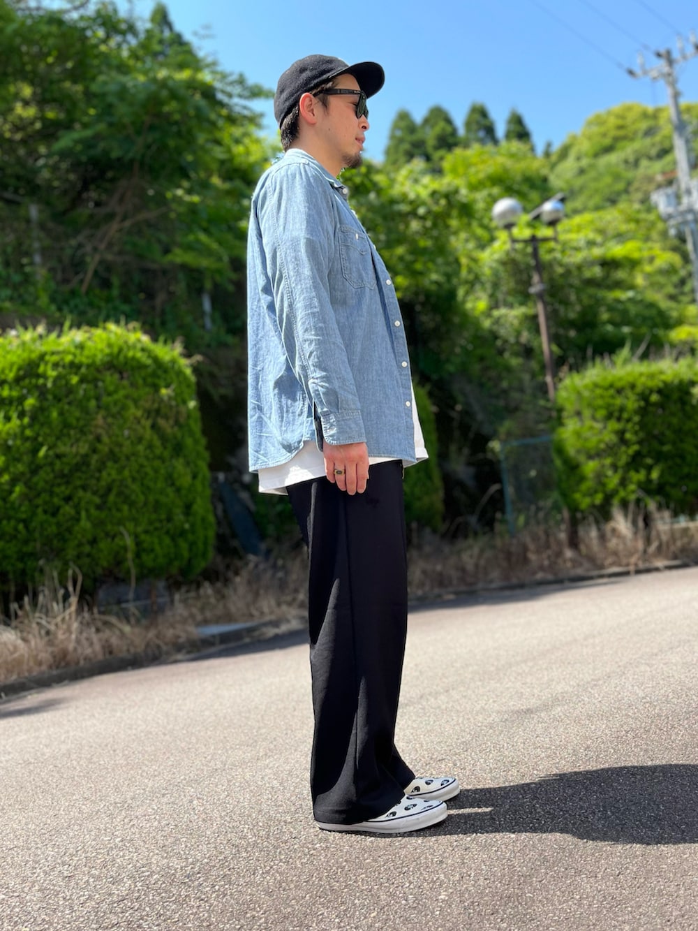 ホワイト系のTシャツ/カットソー、ブラック系のスラックス、ホワイト系のスリッポンを着用したメンズの春コーディネートの4枚目の写真