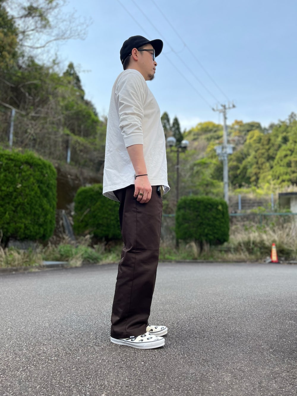 ホワイト系のTシャツ/カットソー、ブラウン系のチノパンツ、ホワイト系のスリッポンを着用したメンズの春コーディネートの3枚目の写真