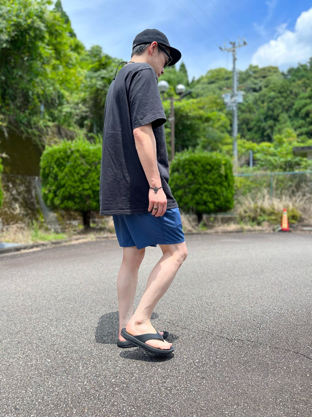 ブラック系のTシャツ/カットソー、ブルー系のパンツ、ブラック系のサンダルを着用したメンズの夏コーディネートの2枚目の写真