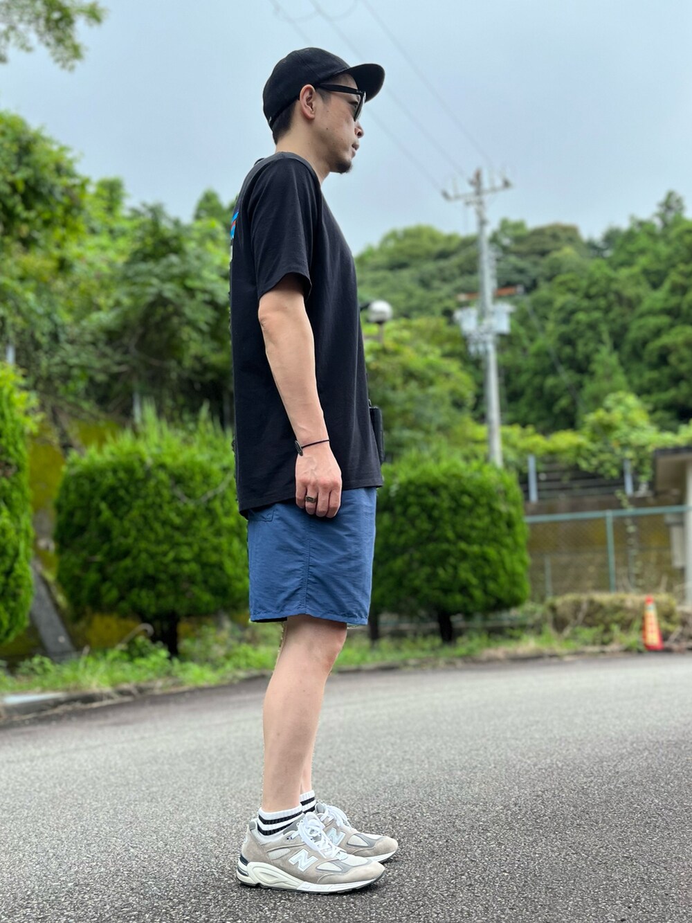 ブラック系のTシャツ/カットソー、ブルー系のパンツ、グレー系のスニーカーを着用したメンズの夏コーディネートの4枚目の写真