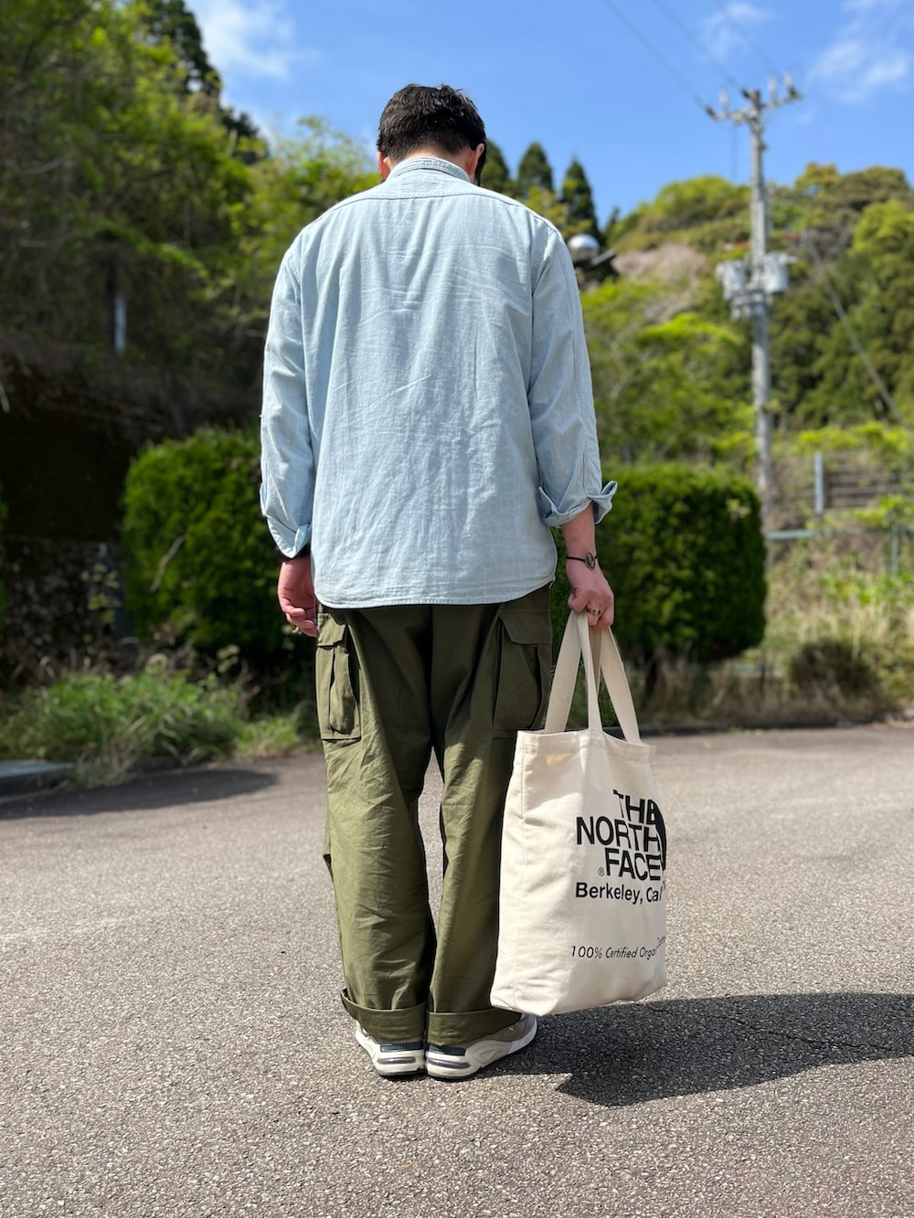 ブルー系のシャツ/ブラウス、ホワイト系のトートバッグ、グリーン系のカーゴパンツを着用したメンズの春コーディネートの3枚目の写真