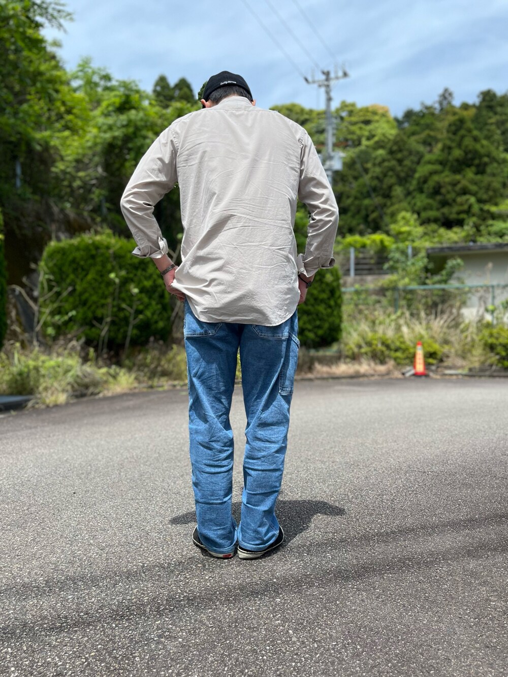 ホワイト系のタンクトップ、ブルー系のパンツ、ブラック系のスニーカーを着用したメンズの春コーディネートの3枚目の写真