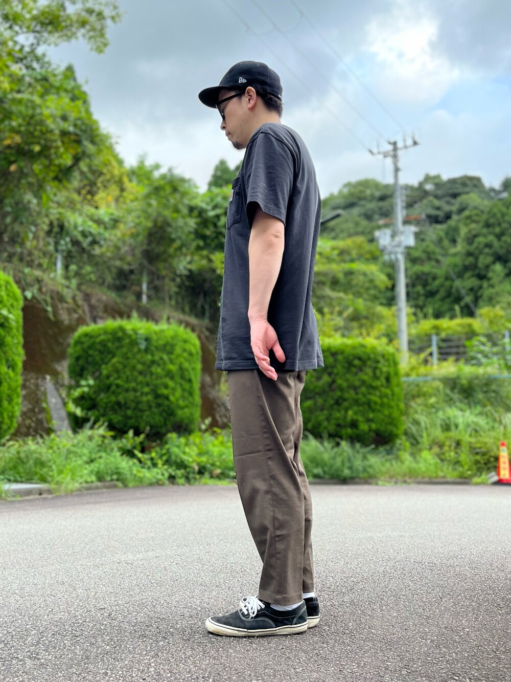 ブラック系のTシャツ/カットソー、ブラウン系のスラックス、ブラック系のスニーカーを着用したメンズの秋コーディネートの2枚目の写真