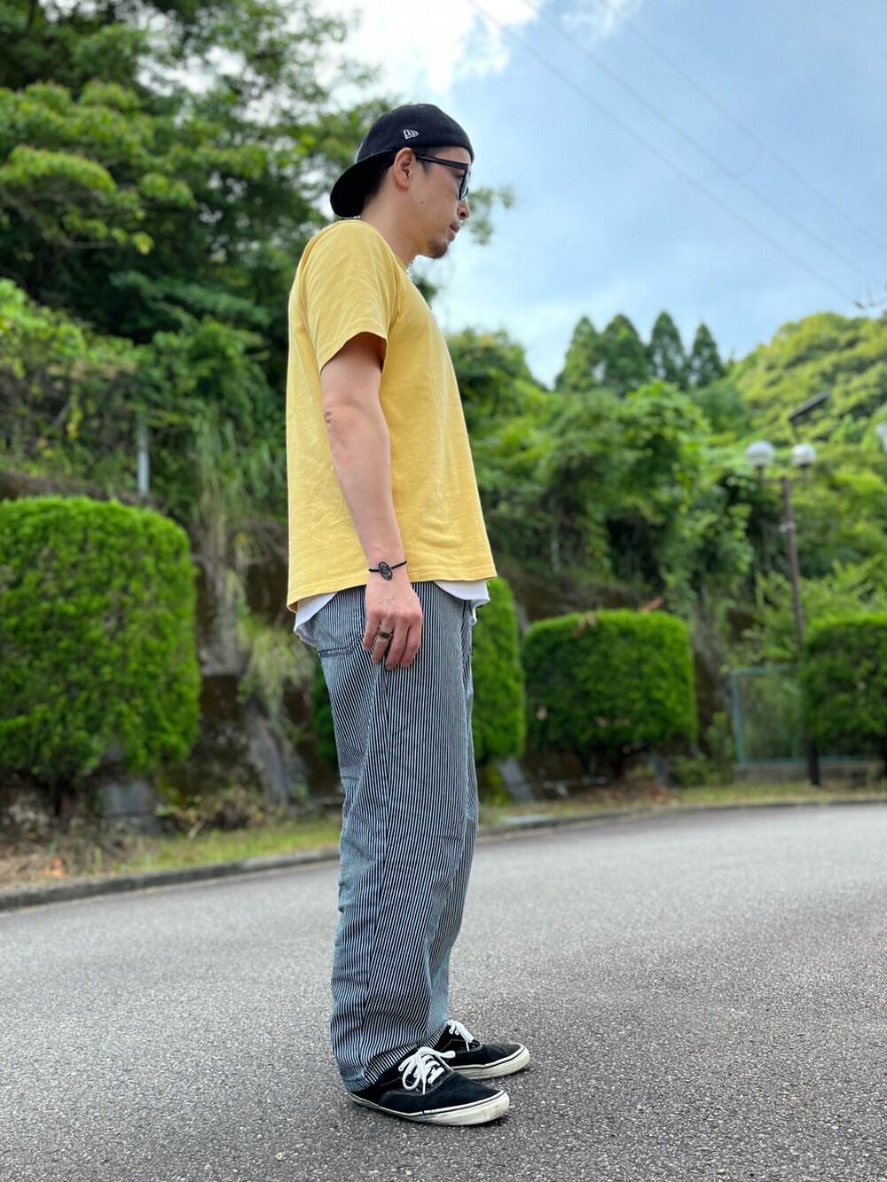 イエロー系のTシャツ/カットソー、ホワイト系のタンクトップ、グレー系のパンツを着用したメンズの夏コーディネートの2枚目の写真