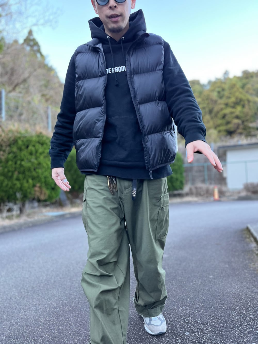 ブラック系のダウンベスト、グリーン系のカーゴパンツ、グレー系のスニーカーを着用したメンズの冬コーディネートの5枚目の写真