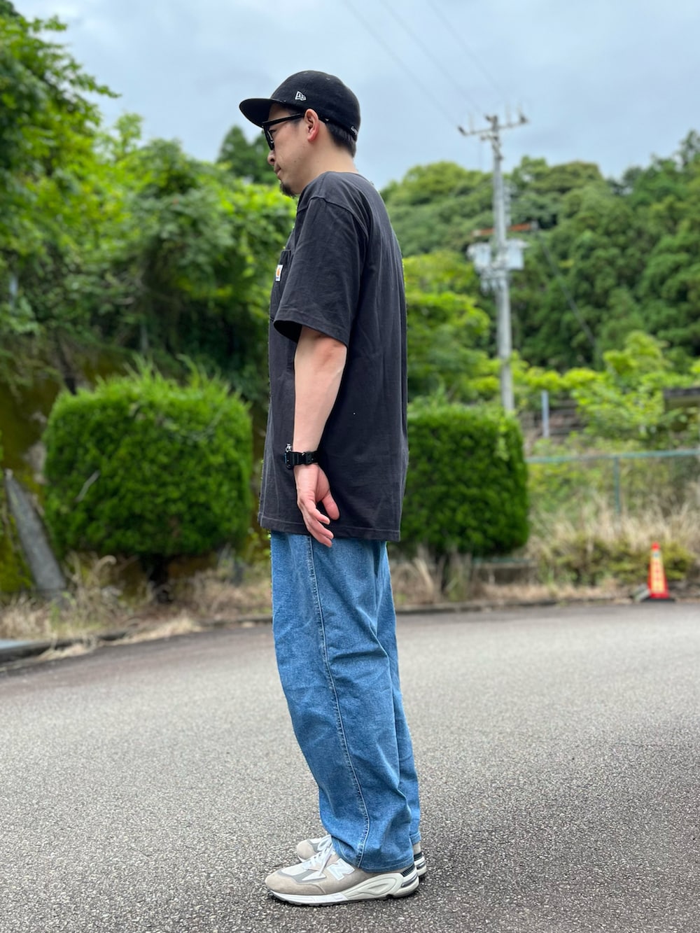 ブラック系のTシャツ/カットソー、ブルー系のパンツ、グレー系のスニーカーを着用したメンズの夏コーディネートの2枚目の写真