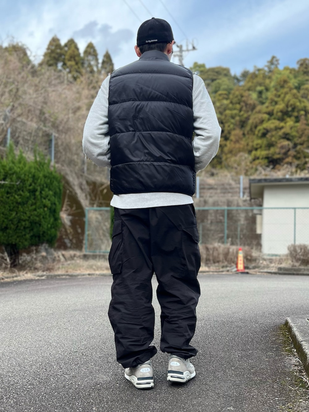 ブラック系のダウンベスト、グレー系のスウェット、ブラック系のパンツを着用したメンズの冬コーディネートの3枚目の写真