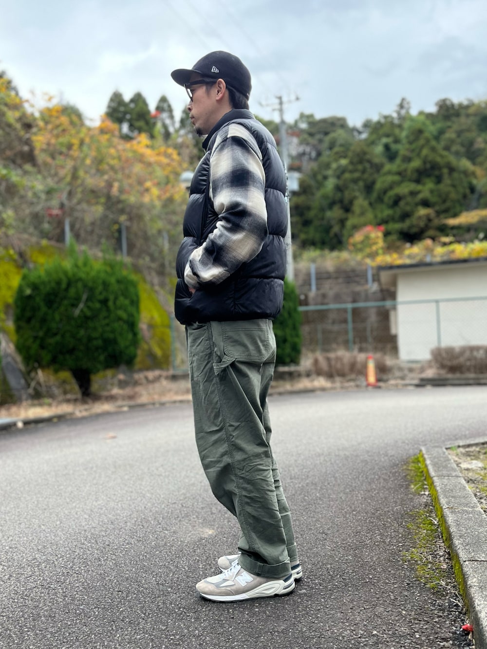 ブラック系のダウンベスト、ブラック系のトップス、グリーン系のパンツを着用したメンズの冬コーディネートの4枚目の写真