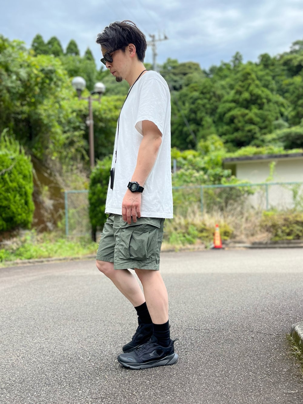 ホワイト系のTシャツ/カットソー、グリーン系のその他パンツ、ブラック系のスニーカーを着用したメンズの夏コーディネートの2枚目の写真